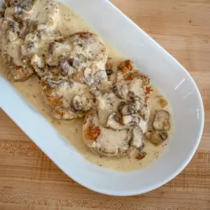 a serving platter with ranch pork chops and sauce