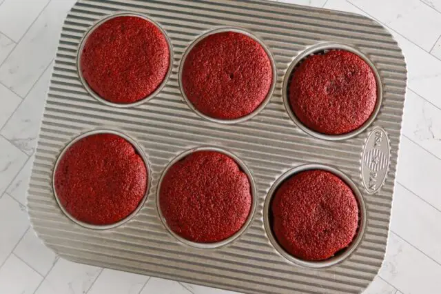 muffin tin with red velvet cupcakes baked