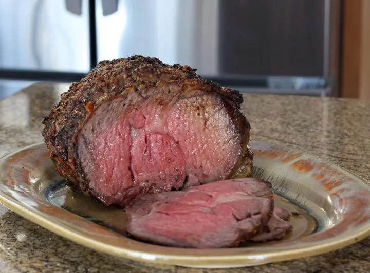 Ribeye roast on a serving tray with one slice cut out