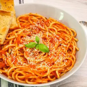 a bowl with pasta tossed with roasted tomato sauce marinara