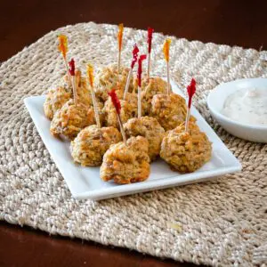 sausage balls on a plate with dip on the side