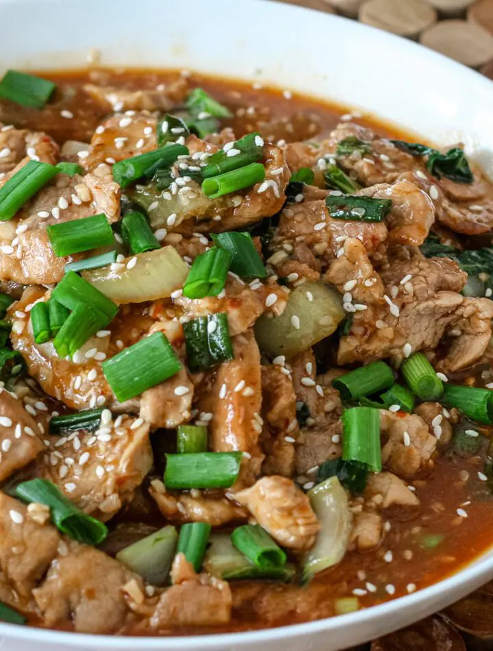 sesame pork with green onions in a bowl