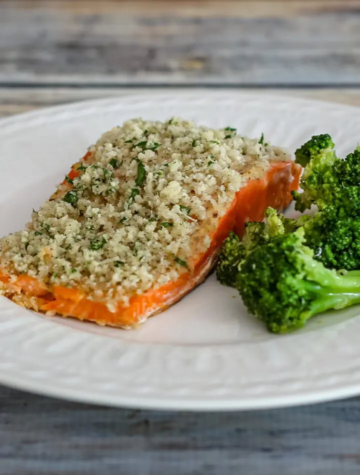 broccoli with lemon shown with a salmon fillet on a plate