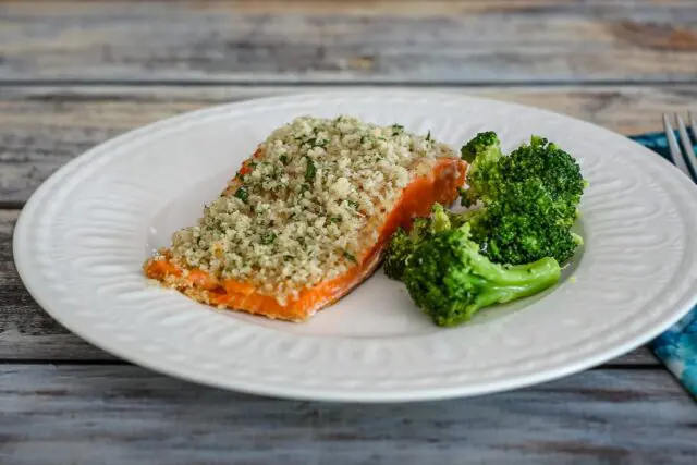 broccoli with lemon shown with a salmon fillet on a plate