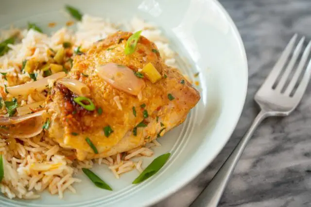 harissa chicken served over rice with its sauce