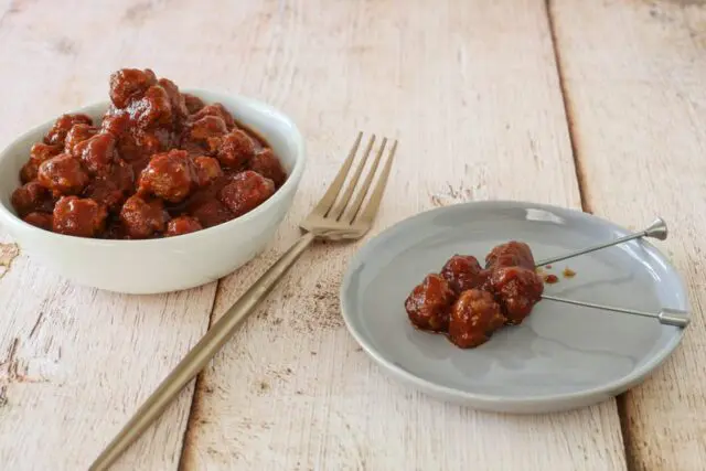 slow cooker barbecue meatballs appetizer in a bowl with a few on a plate