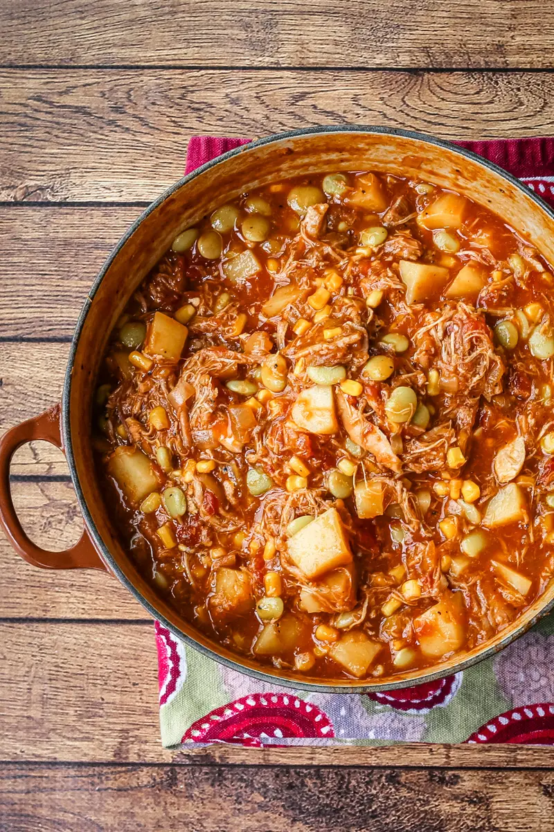 A bowl of rich and delicious Brunswick stew with corn muffins on the side.