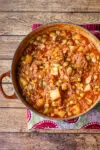 A bowl of rich and delicious Brunswick stew with corn muffins on the side.