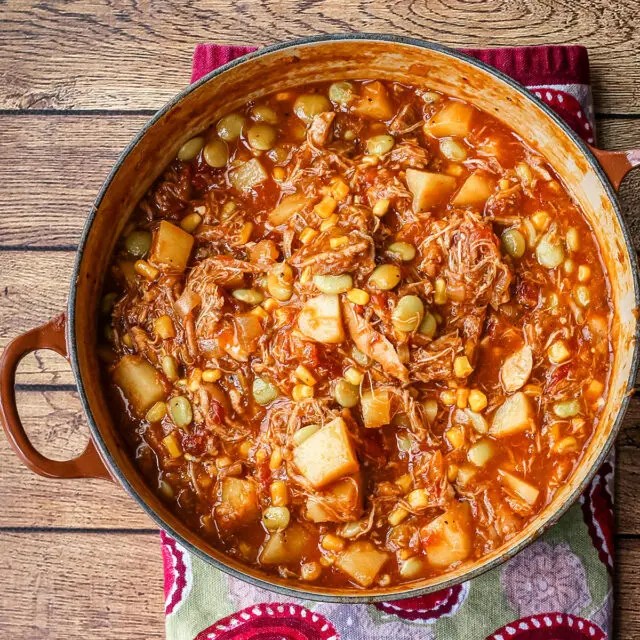 A bowl of rich and delicious Brunswick stew with corn muffins on the side.