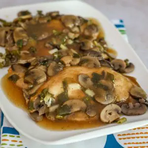 slow cooker chicken marsala with chicken breasts and mushrooms on a serving tray