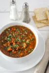 A bowl of slow cooker lentil soup with crackers.