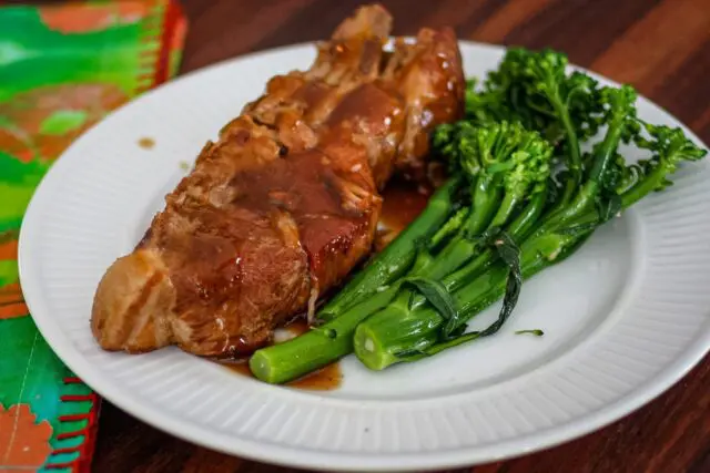 country style ribs with broccolini and barbecue sauce on a plate