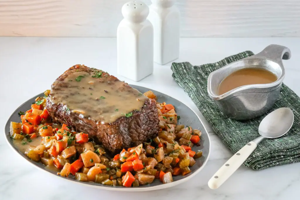 Slow cooker pot roast surrounded with vegetables and gravy