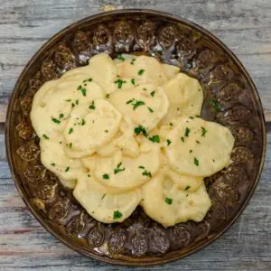 crock pot scalloped potatoes with cheese on a plate