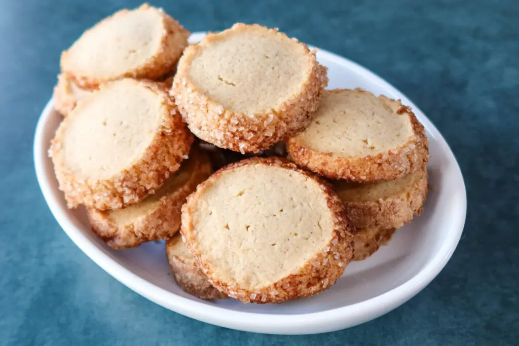 A dish of snickerdoodle sable cookies with cinnamon and sparkling sugar coating
