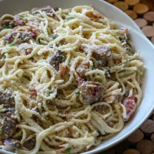 spaghetti with bacon and mushrooms in a serving bowl