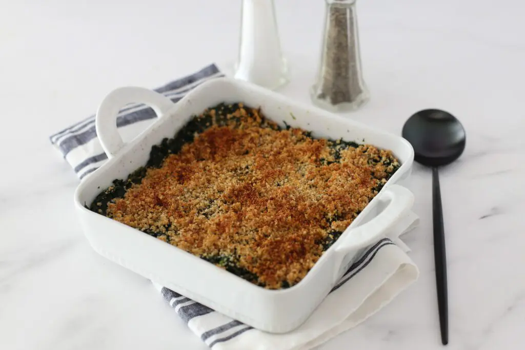 spinach casserole in a baking dish with a spoon