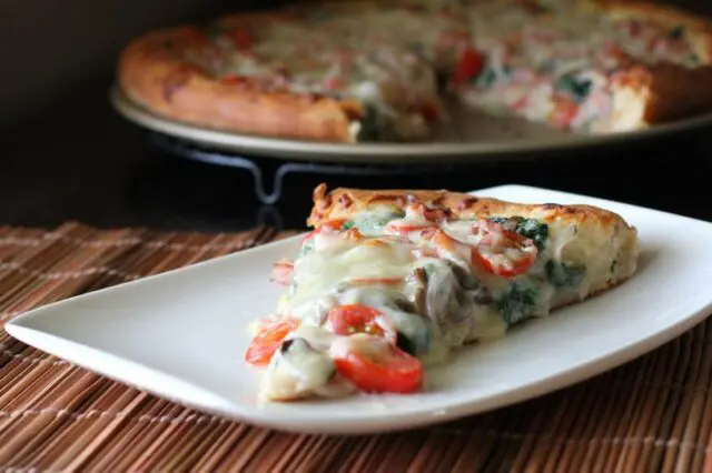 ham and spinach pizza on a plate