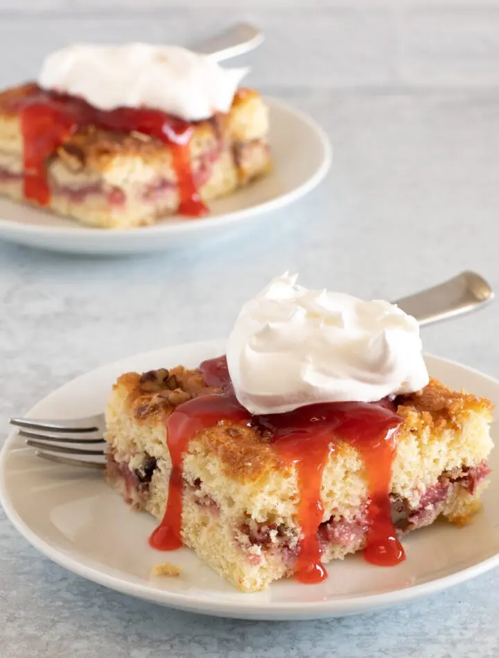 strawberry crumb cakes on plates with strawberry sauce and whipped cream