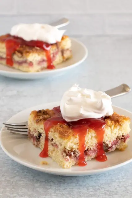 strawberry crumb cakes on plates with strawberry sauce and whipped cream