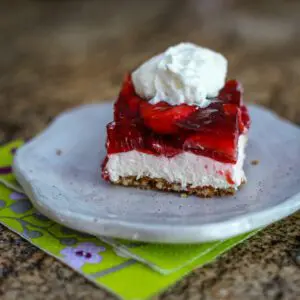 A dessert plate with a slice of strawberry pretzel dessert