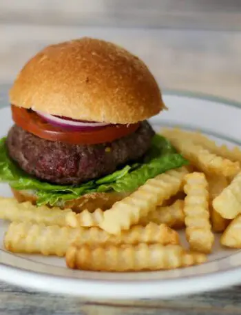 bacon and cheese stuffed burgers on a plate with fries