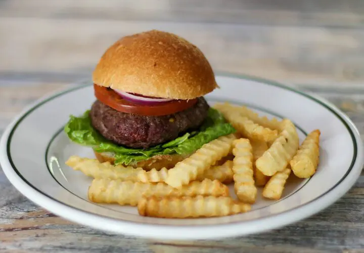 bacon and cheese stuffed burgers on a plate with fries