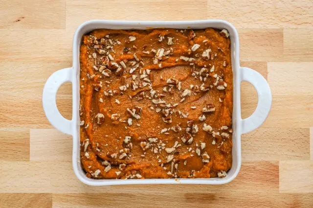 Sweet potato casserole for two prep: in the baking pan with pecans, ready to bake.