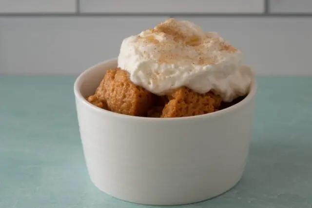 a serving of sweet potato pudding with whipped topping and cinnamon sugar