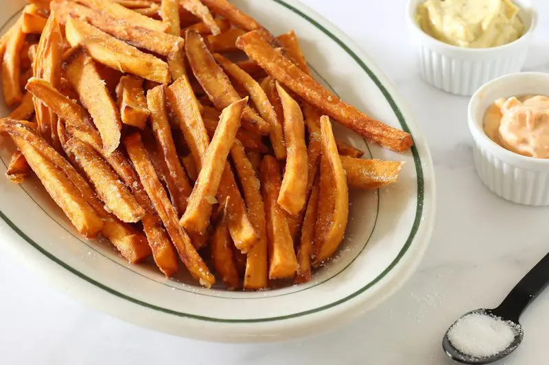 sweet potato fries on a platter with a spicy sweet Thai chili sauce on the side.