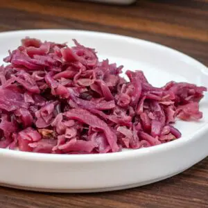 a plate of sweet and sour purple cabbage with apples