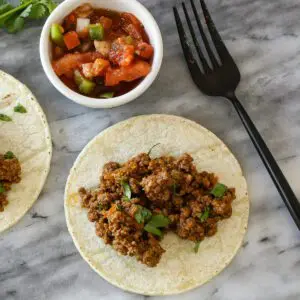 taco meat on tortillas with salsa on the side