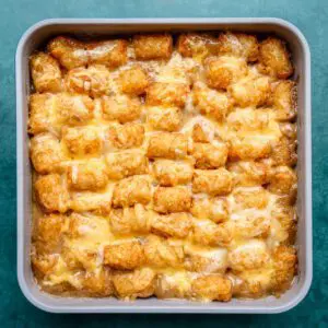 a baking pan of tater tot casserole with cheese topping