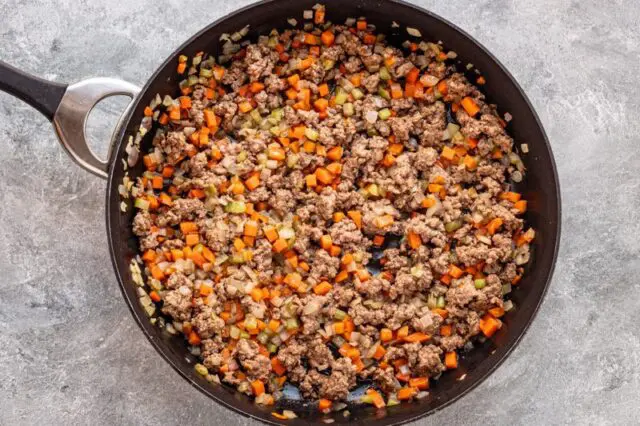 Ground beef (mince) cooked with the vegetables until no longer pink.