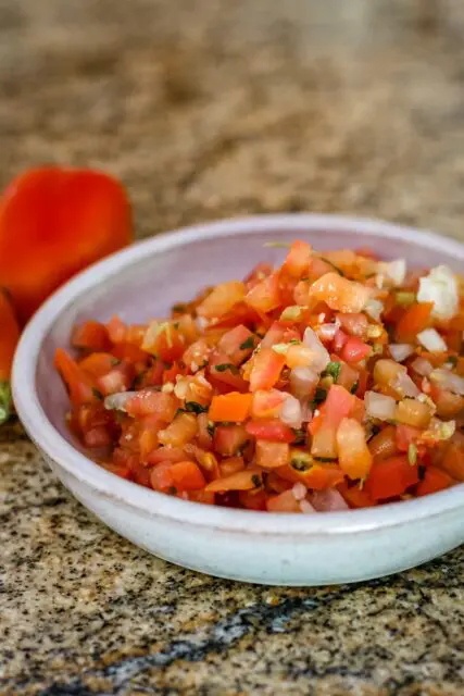 a small bowl of tomato salsa with chile peppers