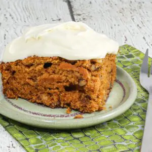 A slice of tomato soup cake with cream cheese icing.