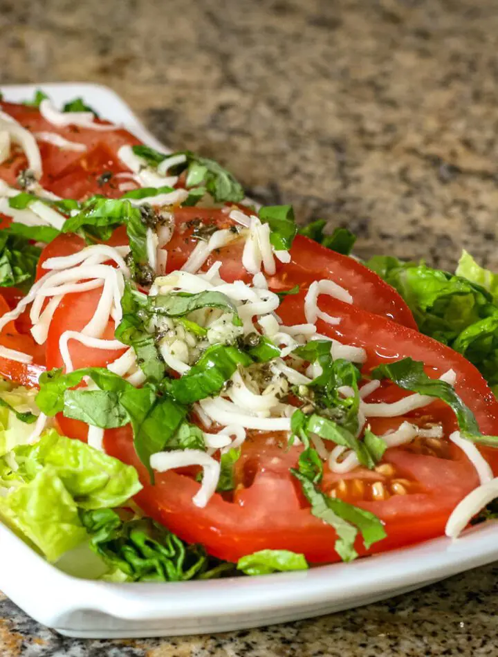 A small serving platter with tomatoes with red wine vinaigrette