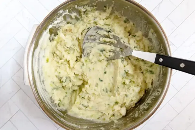 mashing the potatoes and cabbage mixture