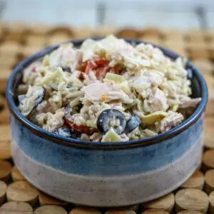 a bowl of tuna and rice salad with artichokes, olives, and tomatoes