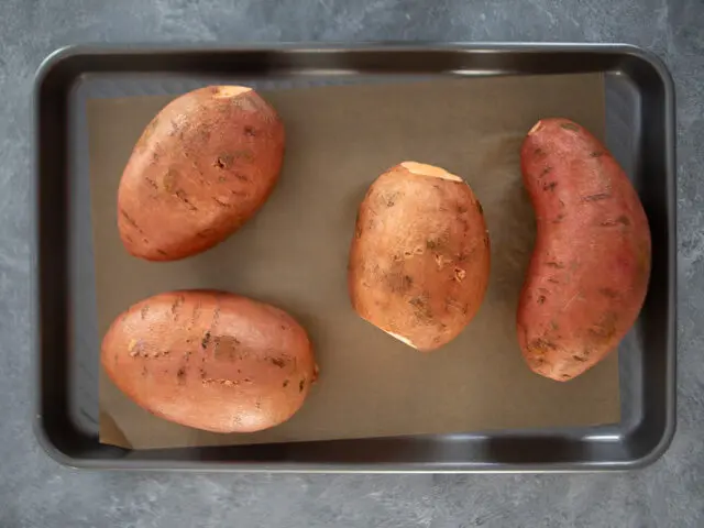 baked sweet potatoes on baking sheet