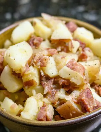 A serving bowl with warm, Cajun flavored potato salad