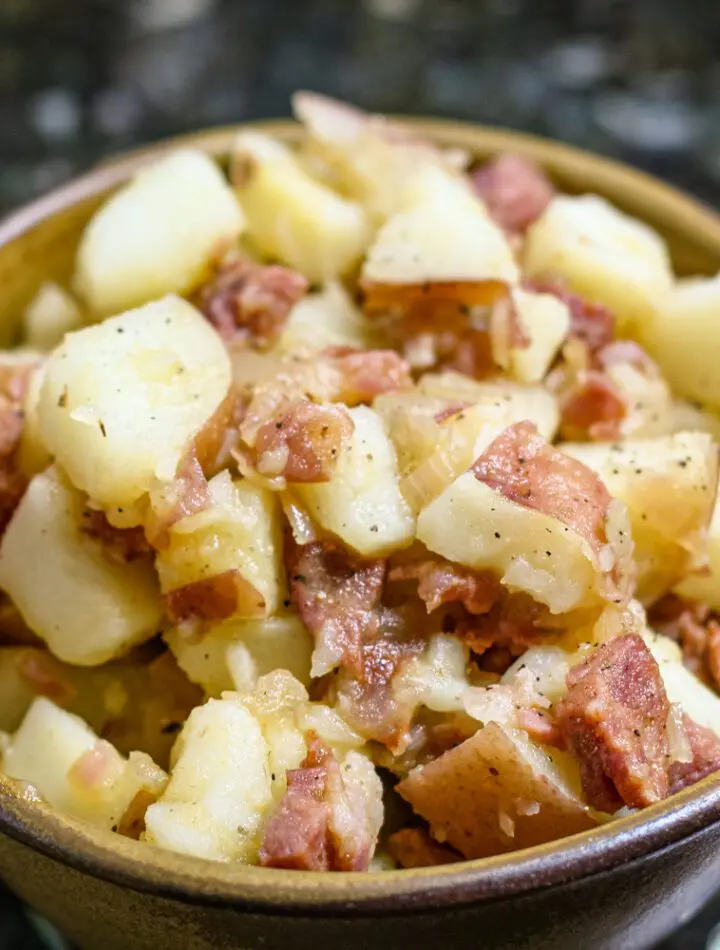 A serving bowl with warm, Cajun flavored potato salad