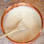 a basic white sauce in a copper saucepan