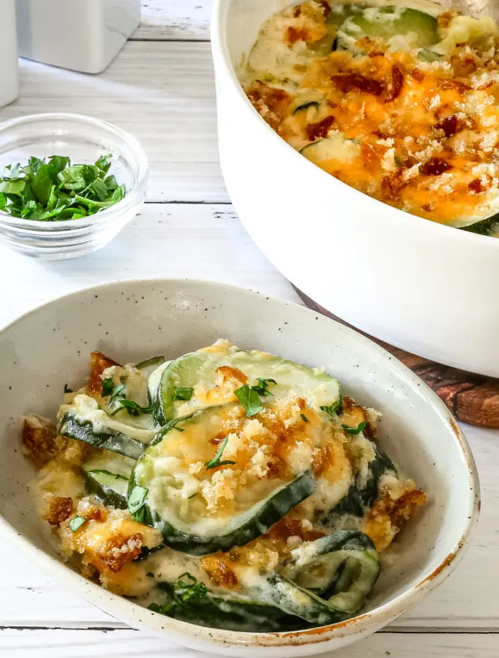 Zucchini casserole on a plate with the baking dish in the