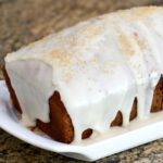 applesauce spice cake on a plate with icing and demerara sugar