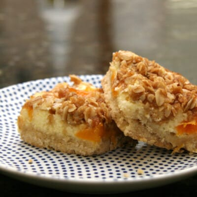 apricot cream cheese bars with shortbread crust and crumb topping, on a plate