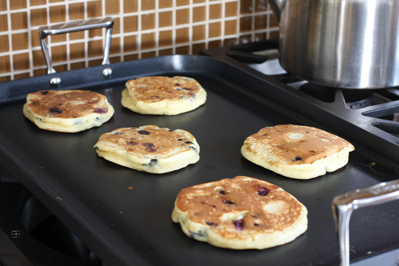 A griddle with blueberry pancakes.