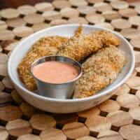 panko coated chicken tenders with dip.