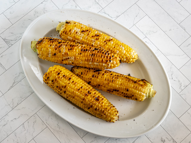 Grilled corn on a platter.