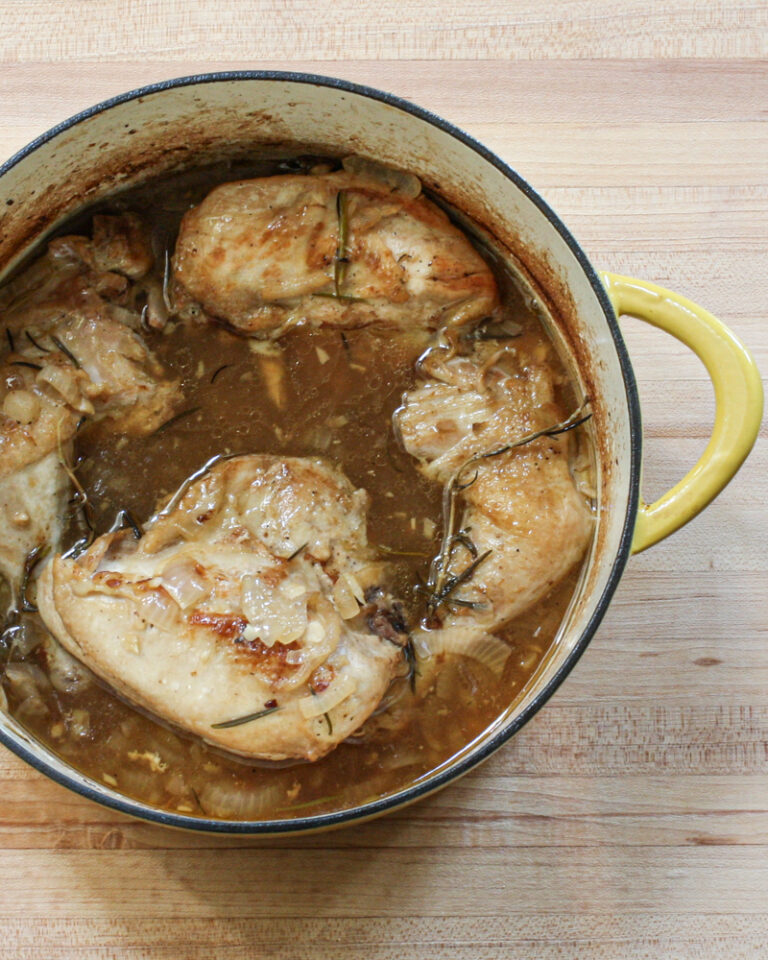 Oven braised chicken with rosemary, shown in the Dutch oven.